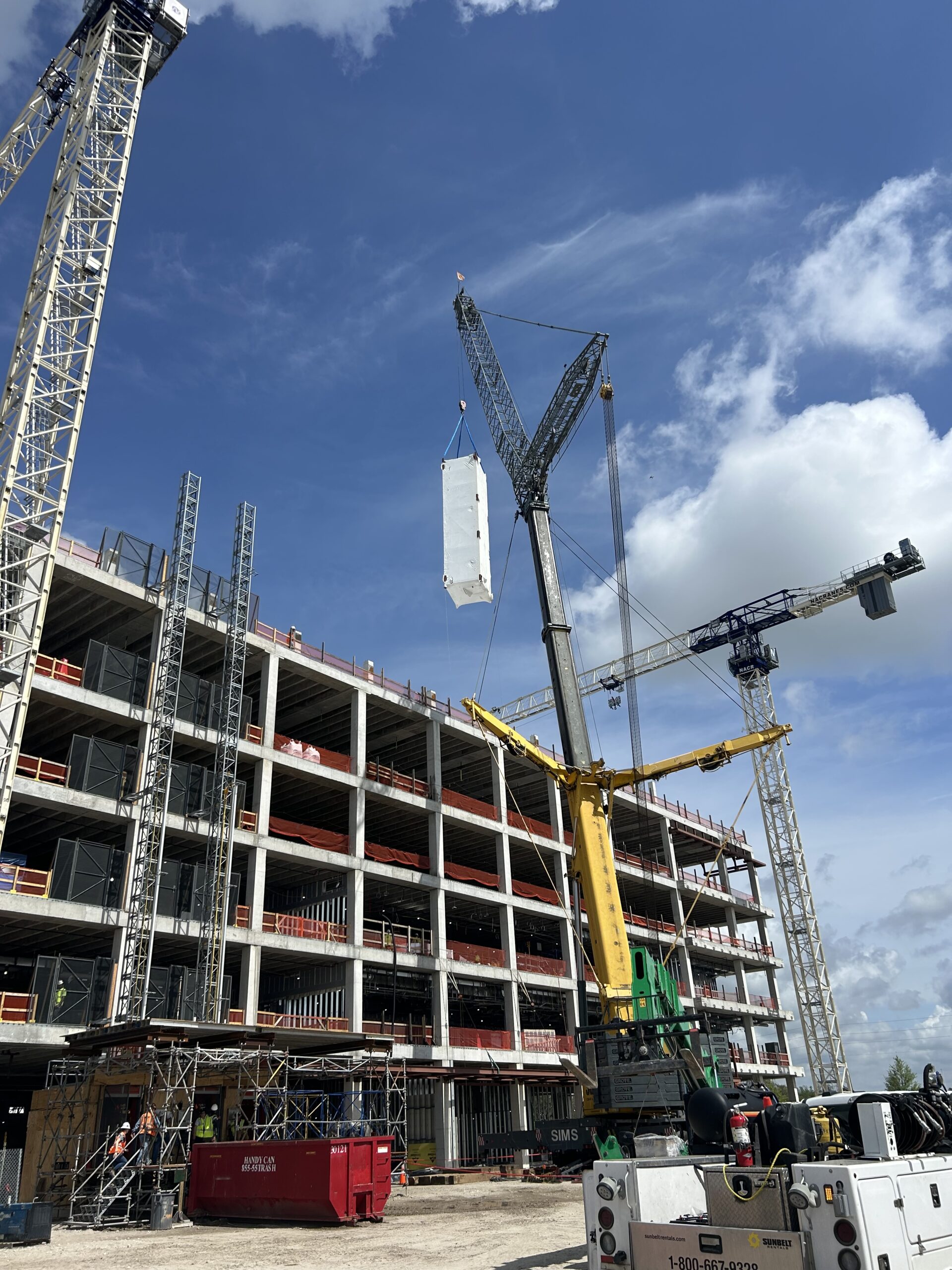 A multi-storey building frame under construction with a crane alongside